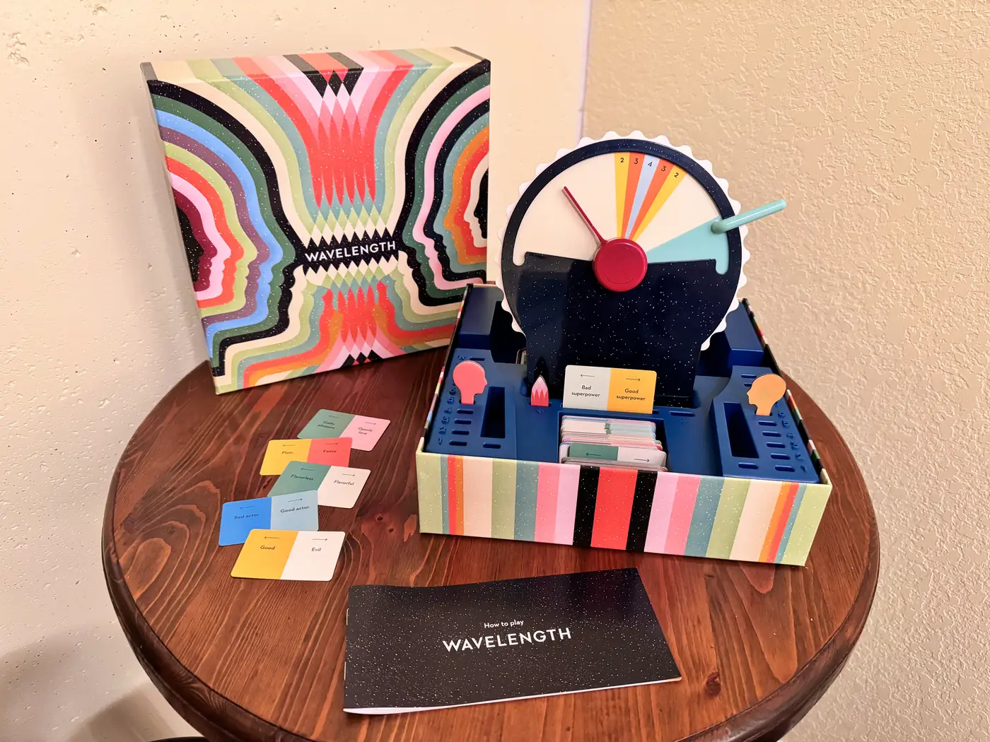 Wavelength board game box, spectrum wheel, cards, and scoring pieces arranged for play